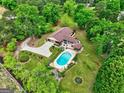 A lush landscaped yard and inground pool surround this well maintained brick home at 171 Wynn Dr, Hampton, GA 30228
