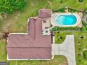 Aerial shot showing a swimming pool, deck, and brick home with a brown shingle roof at 171 Wynn Dr, Hampton, GA 30228