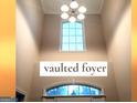 Bright, vaulted foyer showcasing a large window and elegant light fixture at 30 Cynthia Ct, Fayetteville, GA 30215