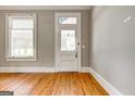 Foyer featuring hardwood floors, decorative glass above the front door, and natural light at 19 Mcdonough St, Hampton, GA 30228