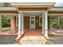 Inviting covered front porch with white columns and a seating area for relaxing at 19 Mcdonough St, Hampton, GA 30228