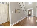 Bright foyer with hardwood floors, staircase, and elegant front door at 8040 Classic Dr, Jonesboro, GA 30236