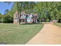Beautiful home featuring a well-maintained lawn and a long driveway leading to the house at 1310 Yarborough Dr, Peachtree City, GA 30269