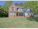 Charming two-story home with a brick and blue facade, set on a well-manicured lawn at 1310 Yarborough Dr, Peachtree City, GA 30269