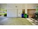 The carport features a door and window leading into the home, with trash cans staged nearby at 1655 Tryon Ne Rd, Brookhaven, GA 30319