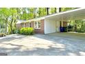 Exterior view of a carport, showcasing the brick and siding detail with nearby landscaping at 1655 Tryon Ne Rd, Brookhaven, GA 30319