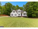 Classic home design with a well-maintained lawn, complemented by lush greenery and a bright blue sky at 190 Ridgecrest Dr, Fayetteville, GA 30215