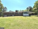 View of the home from the spacious backyard with a screened-in patio at 8315 Ridge Rd, Fairburn, GA 30213