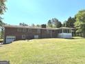 Expansive backyard with a well-maintained lawn and a screened porch at 8315 Ridge Rd, Fairburn, GA 30213