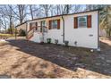 Stylish exterior showcasing the white brick, wooden accents, and front yard of the property at 3650 Adkins Nw Rd, Atlanta, GA 30331