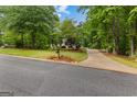 Landscaped front yard of home with long driveway and mature trees, showcasing the property's curb appeal at 40 High St, Sharpsburg, GA 30277