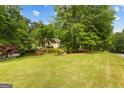 Beautifully landscaped front yard with mature trees and healthy grass, enhancing the home's curb appeal at 40 High St, Sharpsburg, GA 30277