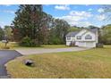 Suburban house with a driveway, set in a large grassy lot and tree-filled landscape at 470 Old Griffin Rd, Hampton, GA 30228