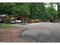 Open driveway with a covered parking spot for one car and several pieces of construction equipment at 208 Holliday Way, Carrollton, GA 30116