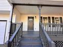 Close-up of the inviting covered front porch with gray wood floors and stairs at 473 Amy Blvd, Temple, GA 30179