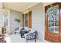 Inviting front porch with seating area, decorative accents, and charming curb appeal at 175 Campaign Trl, Fayetteville, GA 30214