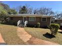 Charming single-story brick home featuring a walkway leading to the front entrance and a well-maintained lawn at 1800 Austin Dr, Decatur, GA 30032