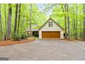 Spacious two-car garage with a well-maintained driveway, set amidst mature trees at 145 Flat Creek Ct, Fayetteville, GA 30214