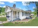 Angle view of a cottage-style home showcasing a stone chimney and covered side porch at 1236 Stone Mountain Lithonia Rd, Lithonia, GA 30058