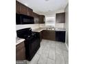 Modern kitchen featuring sleek dark cabinets, stainless steel appliances, and durable gray tile flooring at 4712 Rockstile Way, Stone Mountain, GA 30083