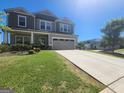 Charming two-story home features a well-kept lawn and driveway, with a visible garage and manicured landscaping at 883 Ironhorse Sw Ln, Mableton, GA 30126
