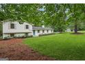 Classic home with light exterior, manicured lawn, pretty landscaping and a long driveway with detached garage at 4327 Welligton Hill Ln, Snellville, GA 30039