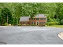 Traditional brick home with mature trees and a circular driveway, offering a peaceful and private setting at 120 Hermitage Pl, Peachtree City, GA 30269