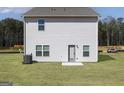 Backyard view featuring a well-manicured lawn and neutral siding with a door and several windows at 488 Cantrell Drive, Dallas, GA 30157