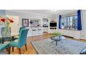 Open living room with blue accents, glass table, hardwood floors, and view into the kitchen at 300 Peachtree Ne Ave # 22N, Atlanta, GA 30305