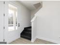 Home entryway featuring stylish vinyl flooring, a stairway with painted risers, and a white exterior door at 446 Cantrell Drive, Dallas, GA 30157