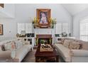 Cozy living room with a charming brick fireplace, bright natural light, and comfortable seating at 140 Braymoor Cir, Fayetteville, GA 30215