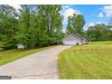 A ranch style home featuring a long driveway, garage, and well maintained lawn at 75 Mcintosh Estates Dr, Sharpsburg, GA 30277