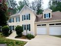 A beautiful two-story home with green shutters, a light stucco exterior and a two car garage at 2980 Milford Sw Trl, Marietta, GA 30008
