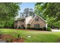 Beautiful two-story brick home featuring mature trees and professionally landscaped front yard at 100 Hartford Pl, Fayetteville, GA 30214
