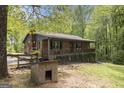 Brick ranch home with a cozy front porch, well-maintained lawn, and mature trees surrounding the property at 165 White Rose Ln, Temple, GA 30179