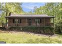 Charming brick home featuring a cozy front porch, mature landscaping, and a welcoming entryway at 165 White Rose Ln, Temple, GA 30179