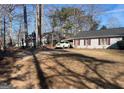 View of the house showing the front yard, driveway and the car port with a white car in it at 3875 Grand Prix St, Cumming, GA 30041