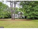 Stately two-story home featuring stone accents, lush landscaping, and mature trees on a sprawling lawn at 80 Jacksons Vly, Sharpsburg, GA 30277