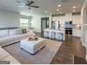 Open living area features hardwood floors, a fireplace, and a view of the modern kitchen at 360 Hayden Cir, Woodstock, GA 30189