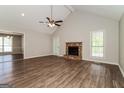 Bright living room featuring a stone fireplace, wood floors, vaulted ceilings, and ample natural light at 8091 Bouldercrest Pl, Douglasville, GA 30135