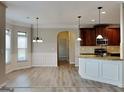 Open kitchen and dining area with updated appliances, granite counters, and hardwood style floors at 305 Mango Ct, Mcdonough, GA 30253