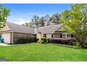 A cozy single-story home boasting lush green lawn and mature trees at 121 Crestwood Ct, Hampton, GA 30228