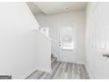 Bright entryway with gray wood-look floors, stairs to the second floor, and a door at 455 Prescott Way, Villa Rica, GA 30180