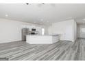 Open-concept kitchen boasts white cabinets, gray countertops, and modern stainless steel appliances at 451 Prescott Way, Villa Rica, GA 30180