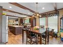 Open-concept dining area featuring wood beams, and a kitchen island with counter seating at 80 David Rd, Hampton, GA 30228