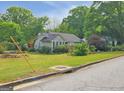 A cozy home surrounded by mature trees and a lush yard, enhancing its curb appeal at 125 Burnside St, Jonesboro, GA 30236
