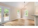 Open dining room with a modern chandelier, hardwood floors, and natural light through the windows at 405 Sherrels Frd, Peachtree City, GA 30269