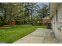 Expansive backyard featuring a concrete patio and mature trees, perfect for outdoor entertaining at 7017 Sun Valley Way, Riverdale, GA 30274