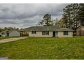 Charming single-story home with white brick exterior and well-manicured lawn at 7017 Sun Valley Way, Riverdale, GA 30274