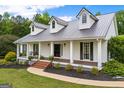 Charming home featuring a metal roof, inviting porch, and beautifully landscaped front yard at 333 Old Carrollton Rd, Roopville, GA 30170